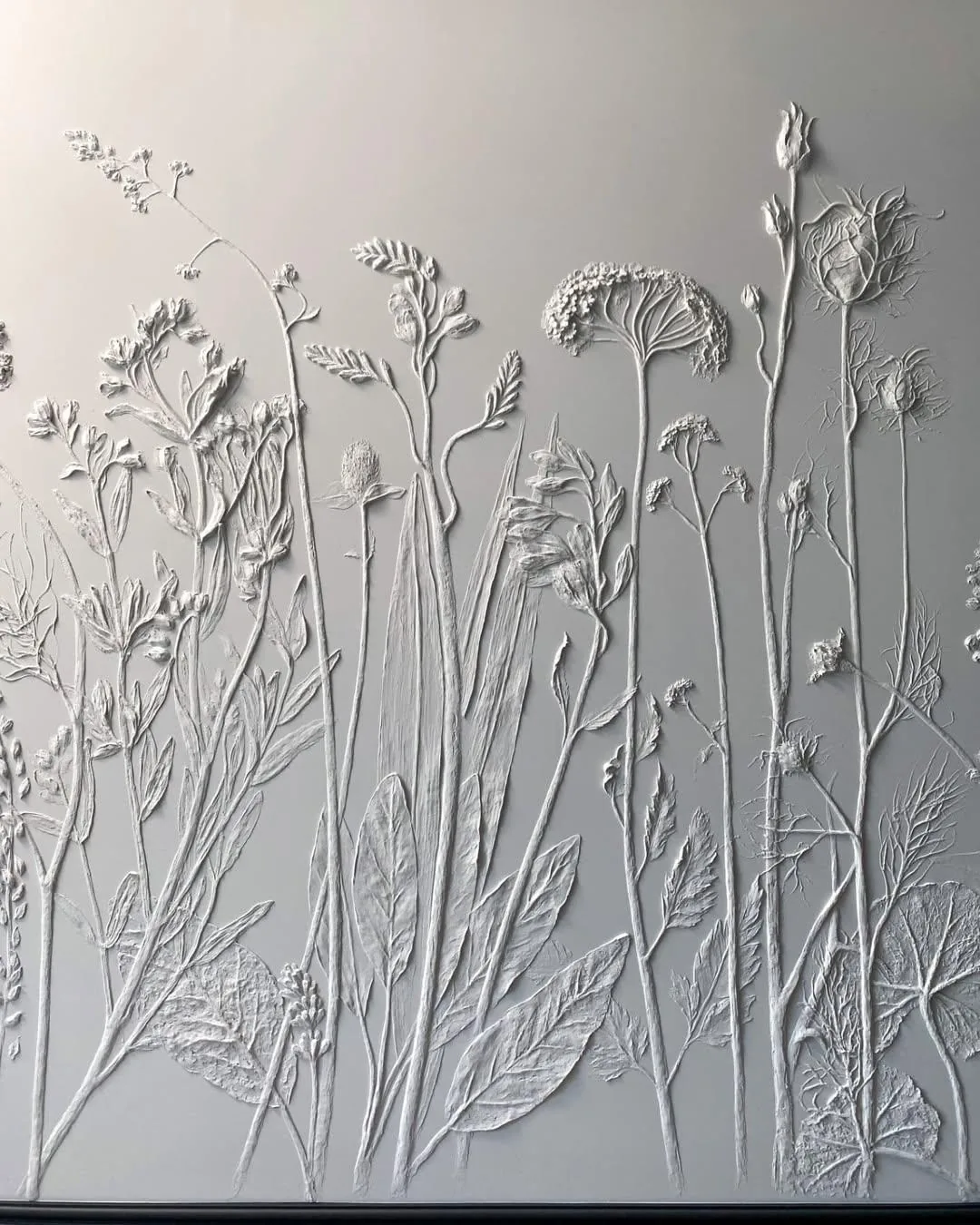 Close detail of sculptural flowers and leaves on a wall